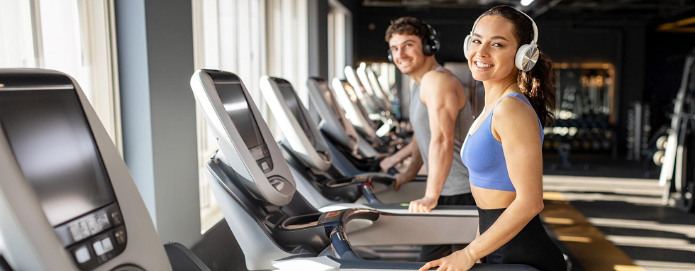 VO2 max - mężczyzna i kobieta ćwiczą uśmiechnięci na bieżni